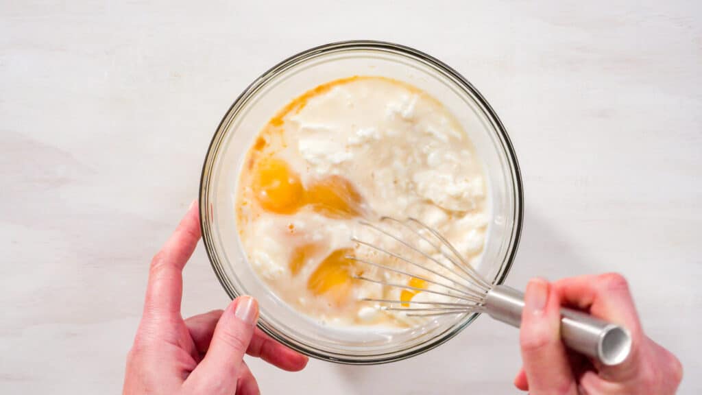 Best Italian Cream Cake From Cake Mix 4 Glass bowl of cake mix for Italian Cream Cake From Cake Mix being mixed by whisk.