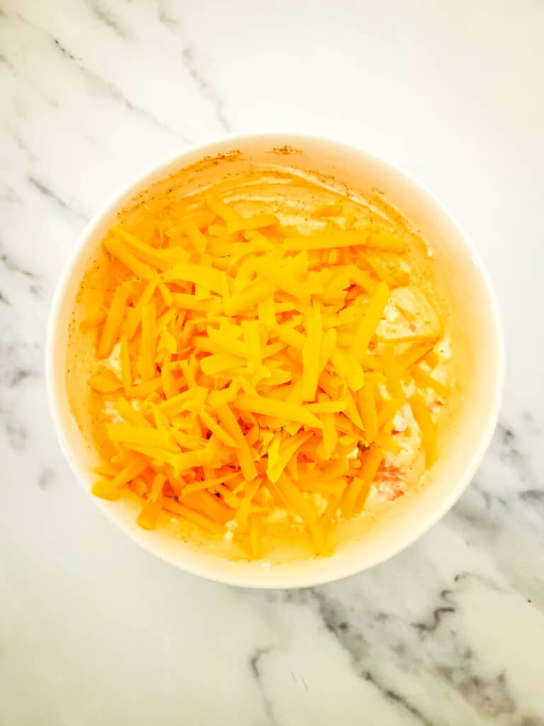 Old Fashioned Pimento Cheese Recipe 6 Shredded sharp cheddar added to a bowl of pimento cheese mixture.