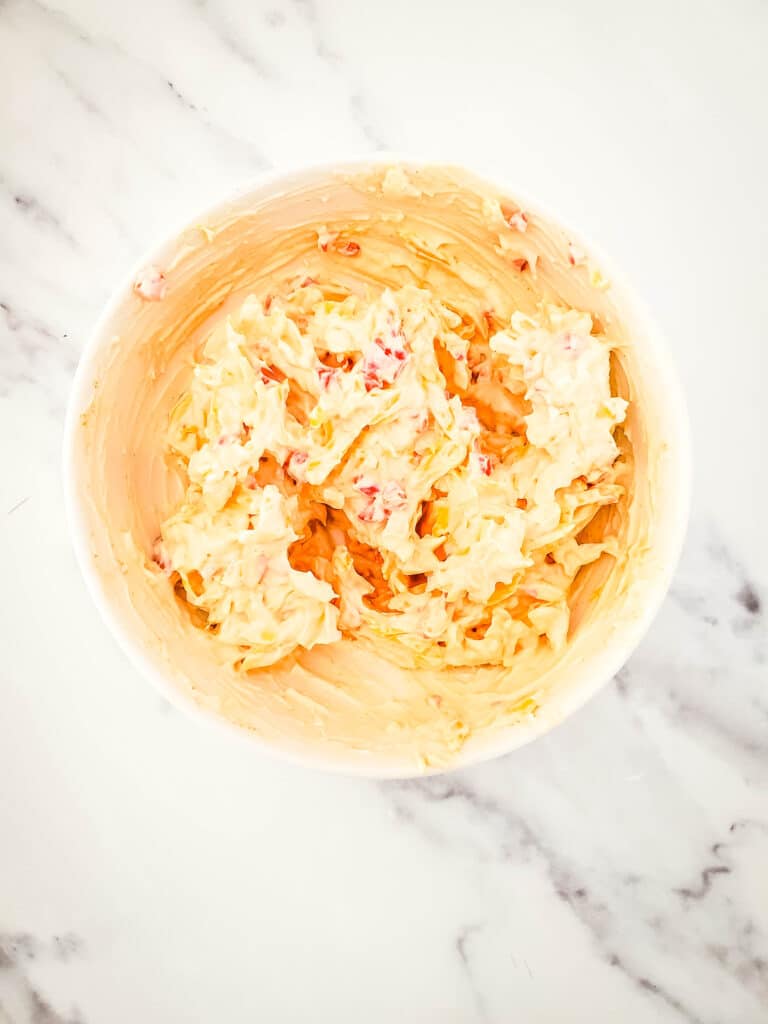 Old Fashioned Pimento Cheese Recipe 7 Pimento cheese mixture in a bowl on a marble countertop.