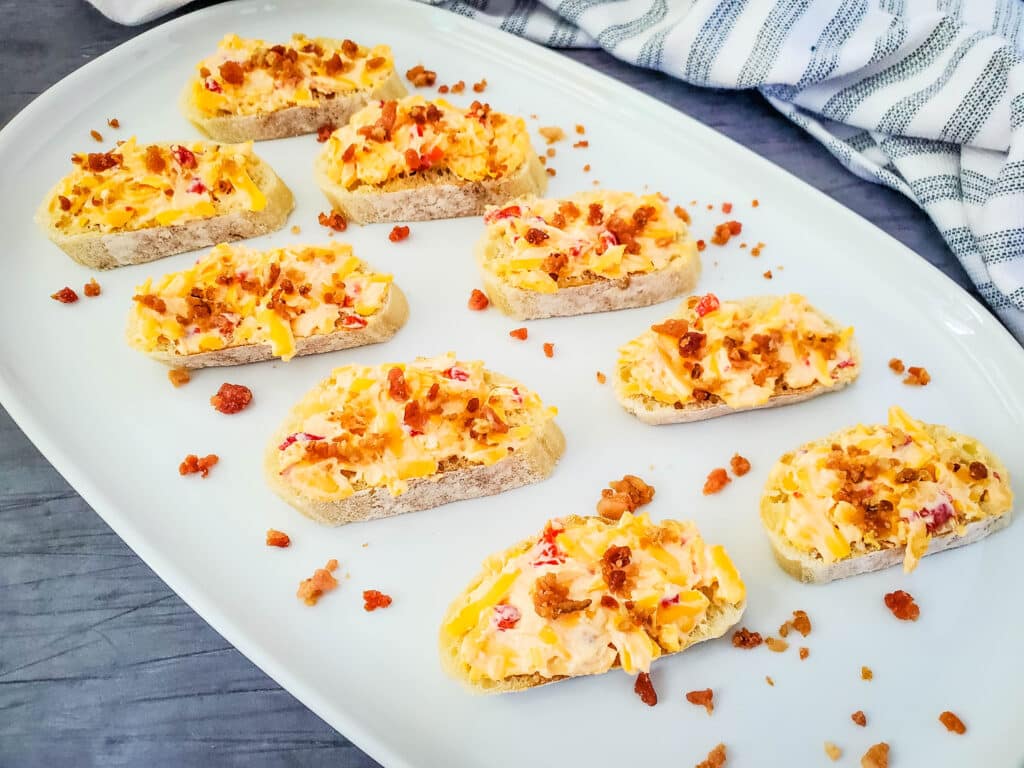 Old Fashioned Pimento Cheese Recipe 9 Old Fashioned Pimento cheese and bacon crostini on a white serving platter.