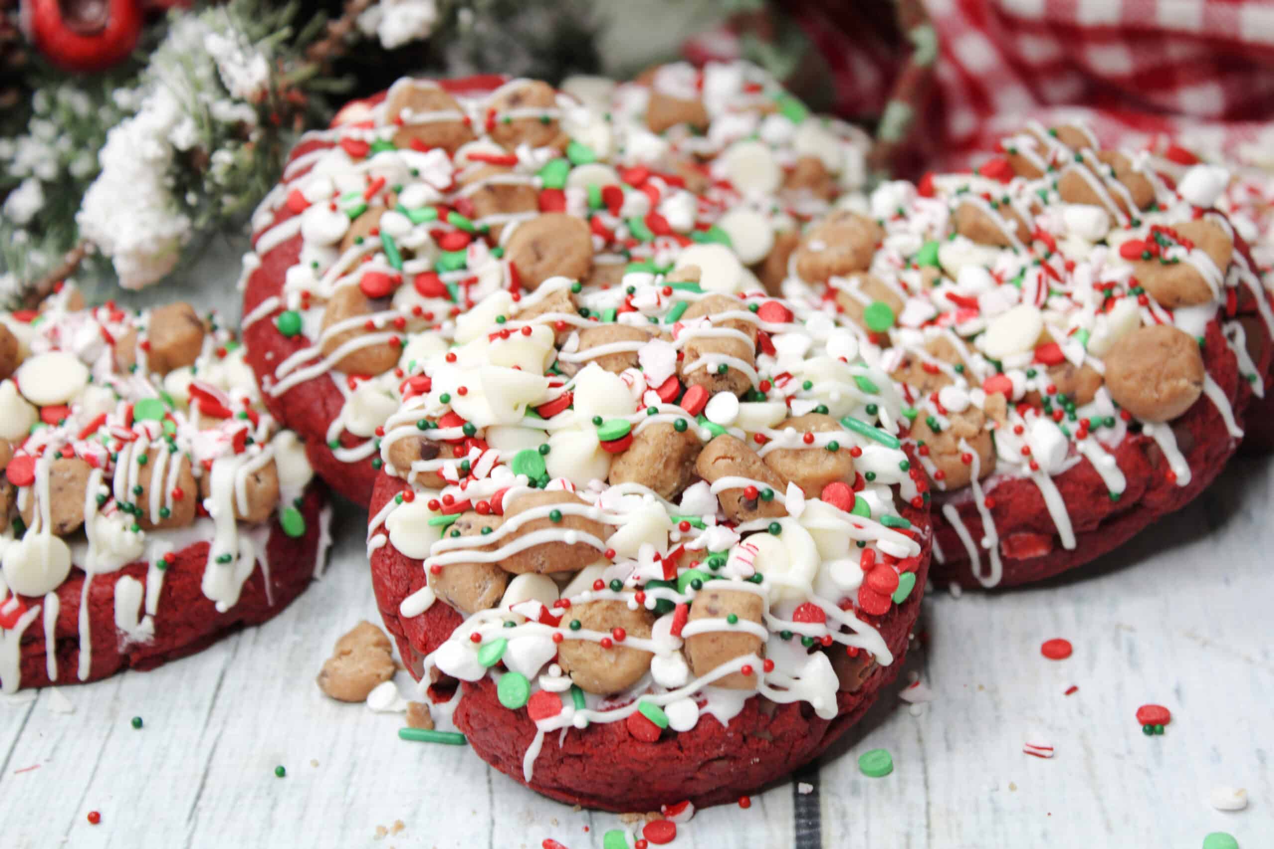 Batch of Santa's cookies on a white wooden countertop with Christmas decorations in the background.