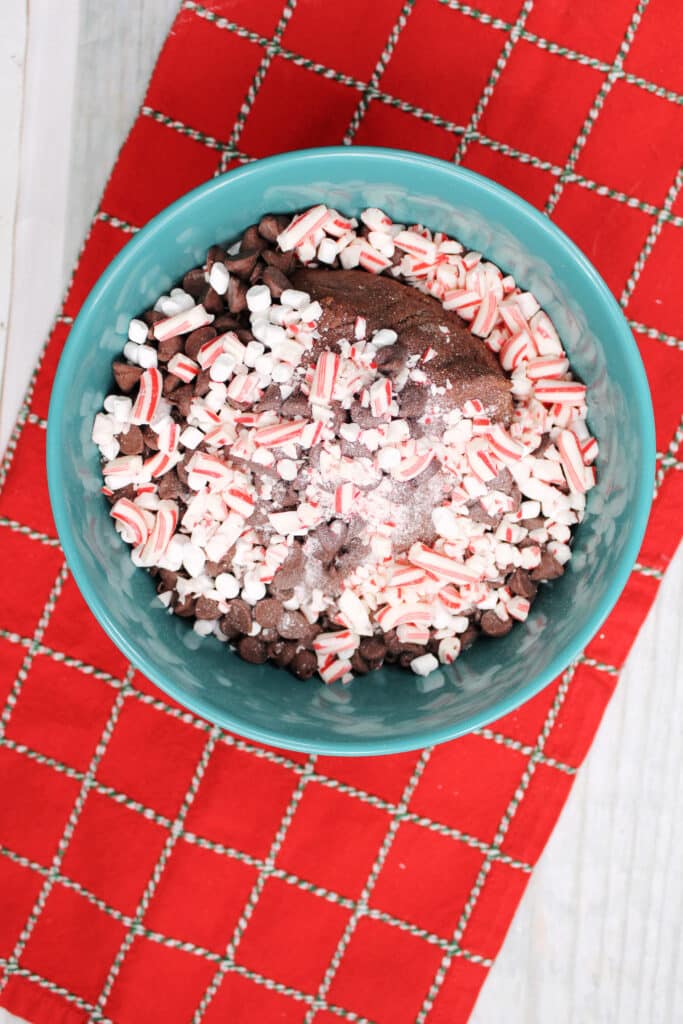 Santa's Cookies (Red Velvet Christmas Cookies) 7 Overhead view of chocolate chip cookie dough with mini marshmallows and candy canes.