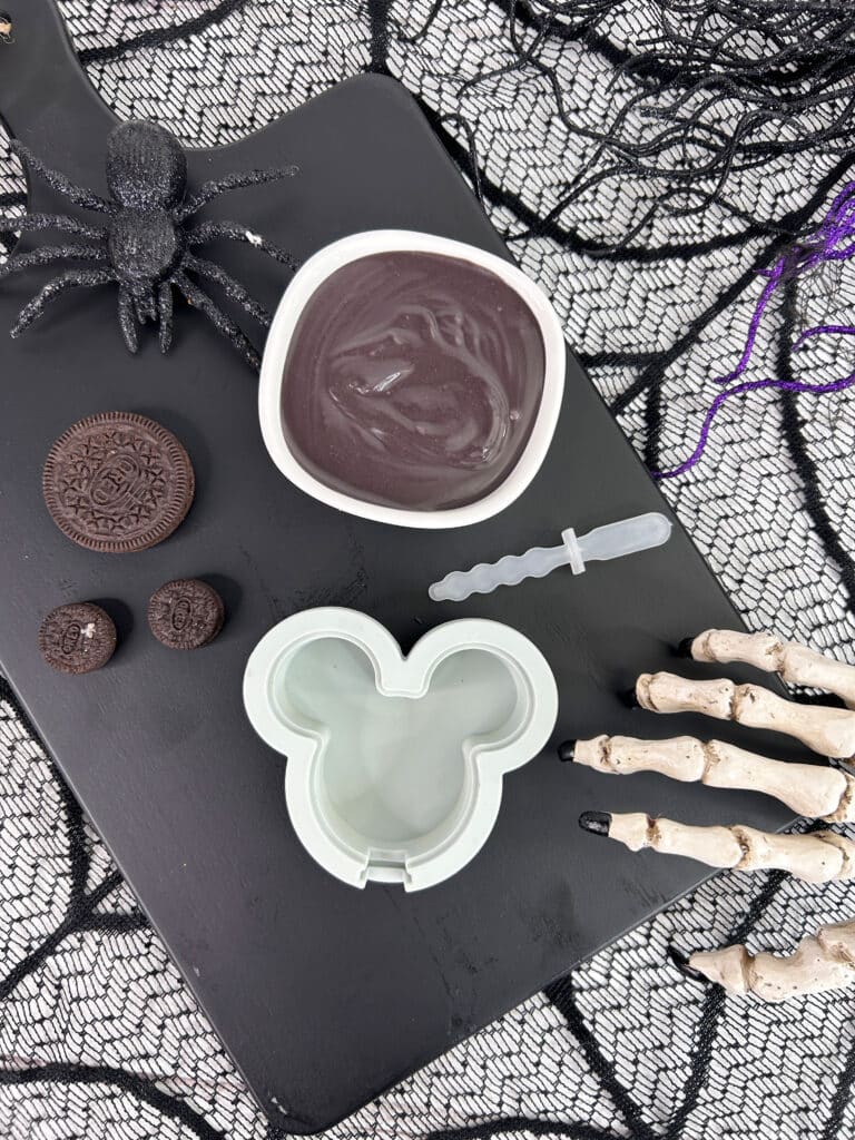 Disney Halloween Recipe (Mickey Oreo Pops) 4 overhead view of mickey mold, melted chocolate and spider