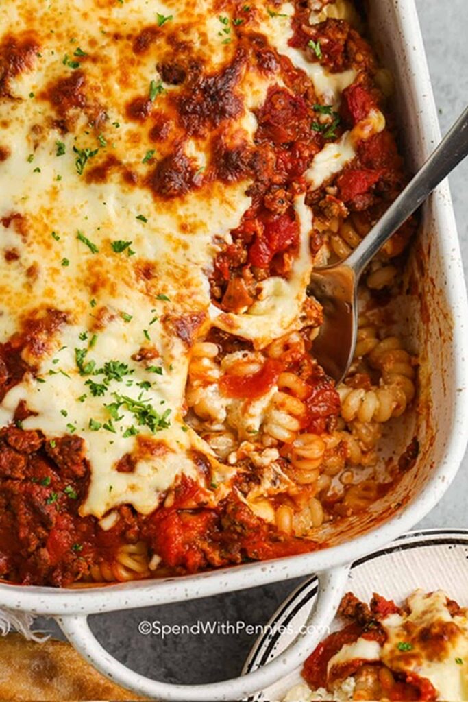 25 Venison Burger Casserole Recipes 11 Ground venison casserole in a white casserole dish with a metal spoon.