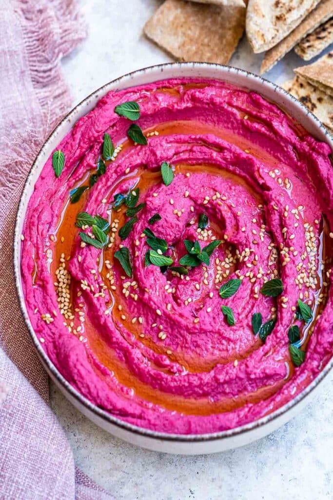 25 Christmas Appetizers That Travel Well 48 Overhead view of a bowl of roasted beetroot hummus.