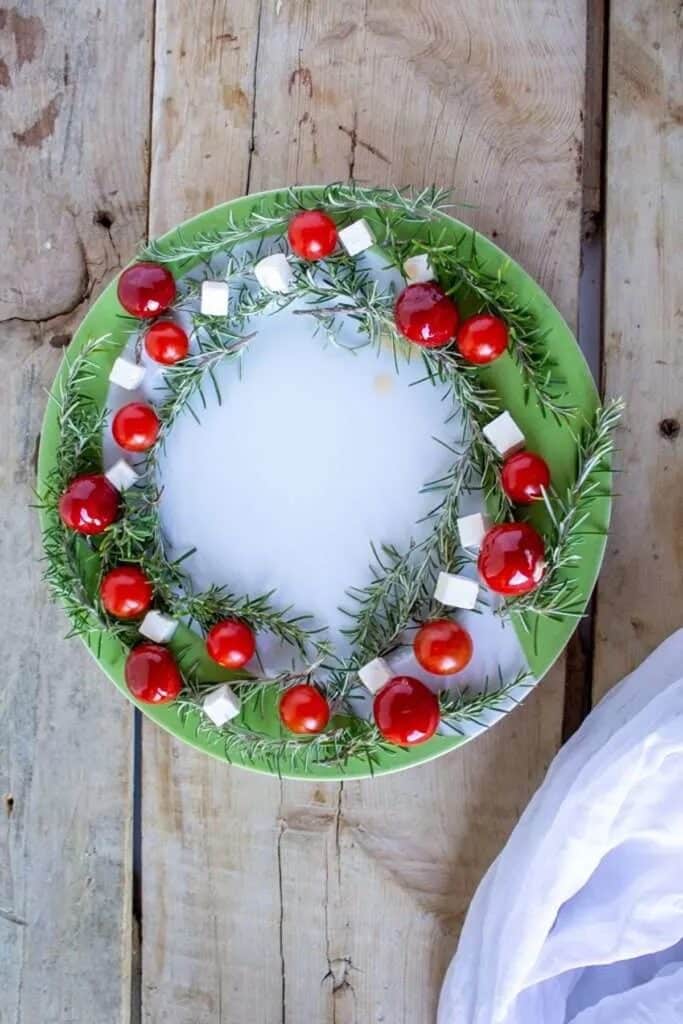 25 Christmas Appetizers That Travel Well 52 Christmas charcuterie wreath on a wooden surface.