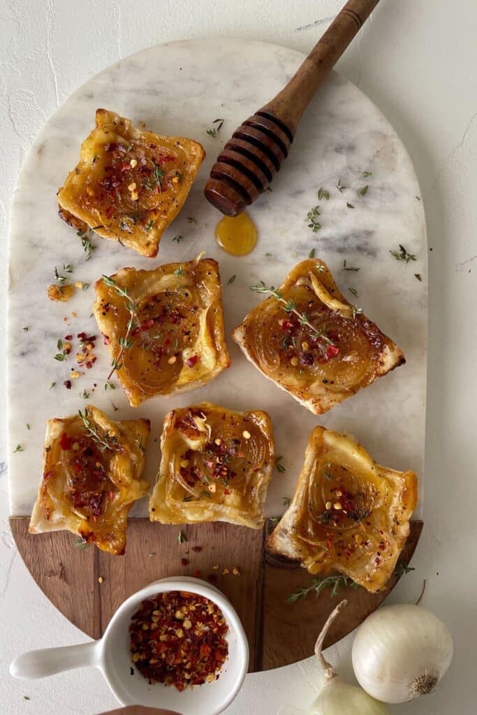 25 Christmas Appetizers That Travel Well 38 Upside down onion tarts on a white marble platter.
