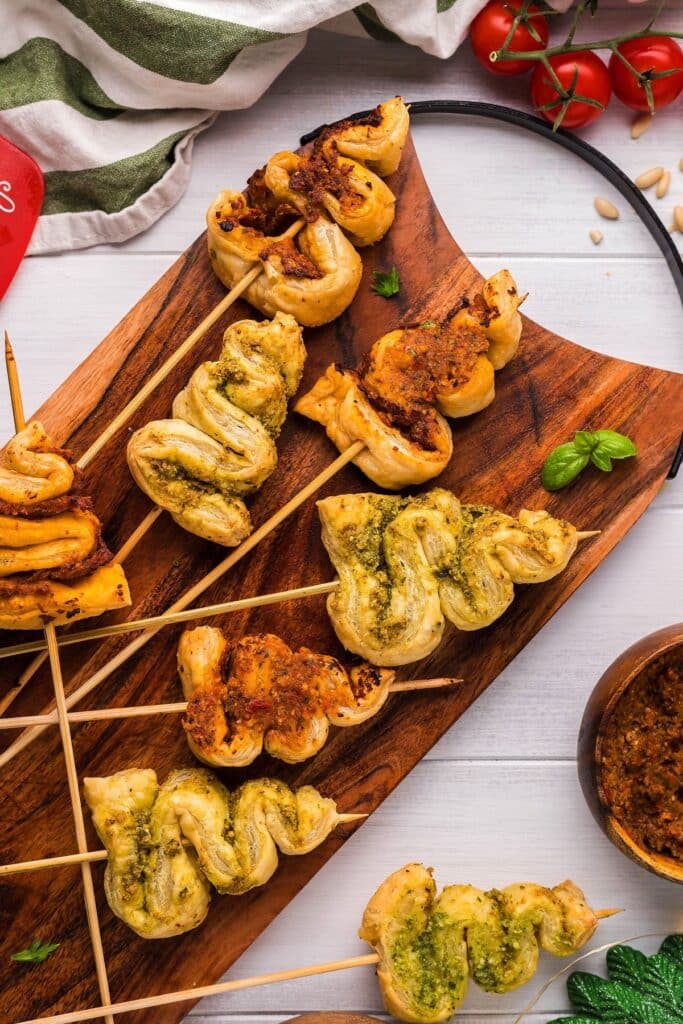 25 Christmas Appetizers That Travel Well 39 Pesto puff pastry Christmas tree appetizers on a wooden board.