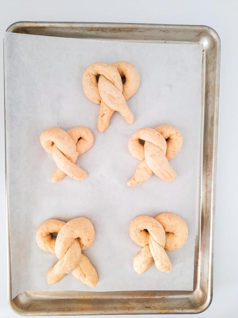 Sourdough Discard Pretzels 14 pieces of sourdough dough in pretzel shape on parchment paper lined baking sheet