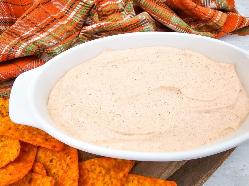 The finished 2-Ingredient Taco Dip surrounded by Doritos and a tea towel.