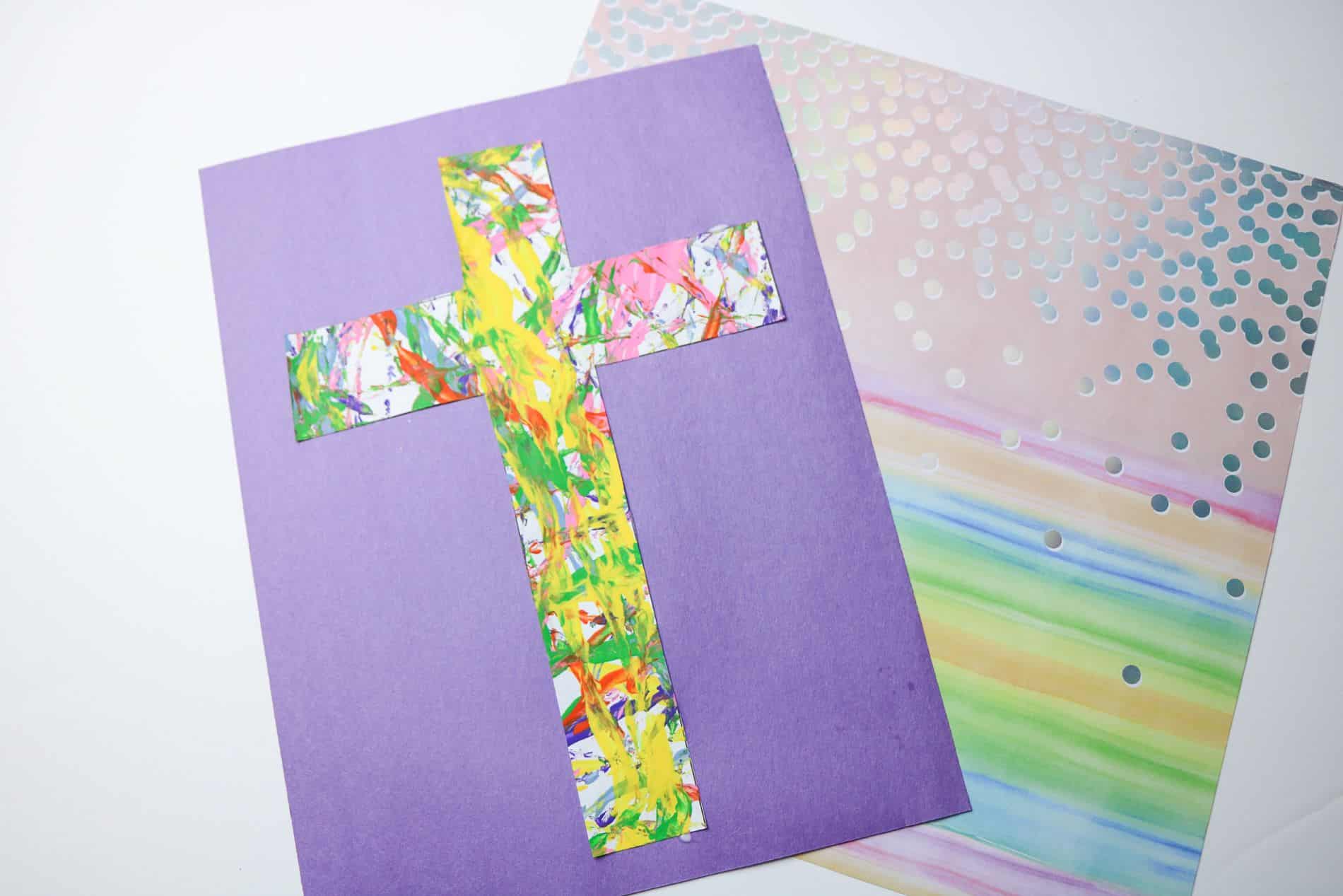 Flat lay shot of the finished Cross Marble Painting pasted on purple colored paper.