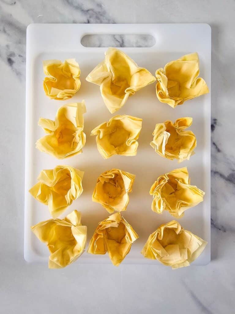 Flat lay shot of the baked phyllo pastry cups on a white chopping board.