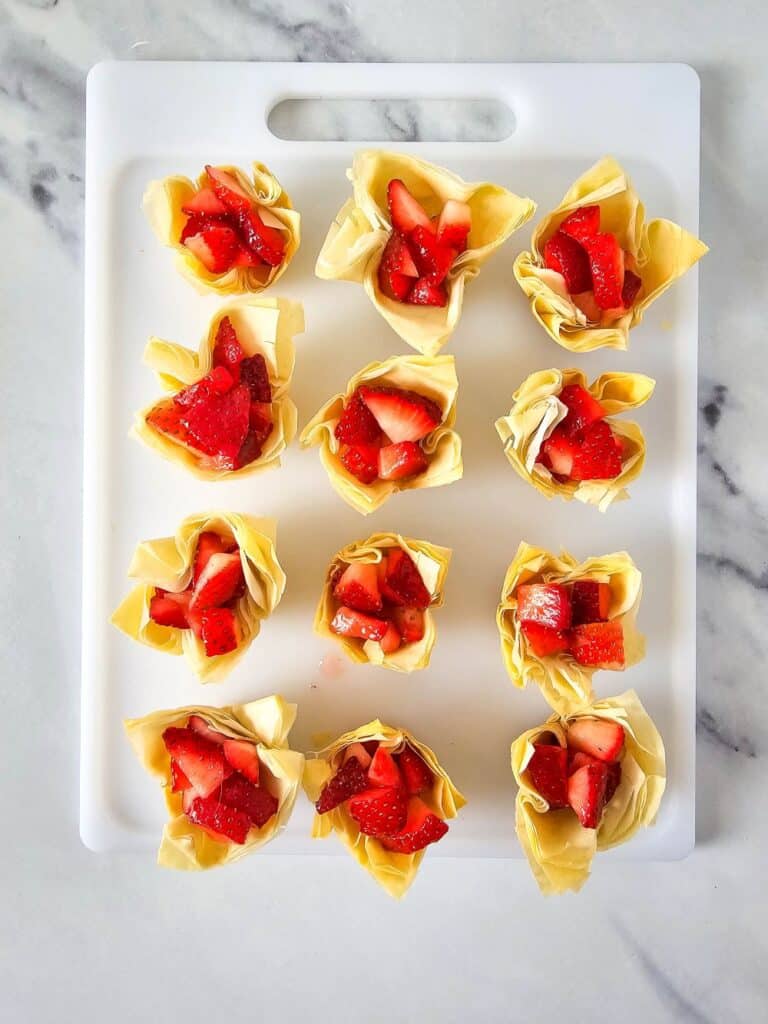 Flat lay shot of the phyllo pastry cups topped with chopped strawberries.