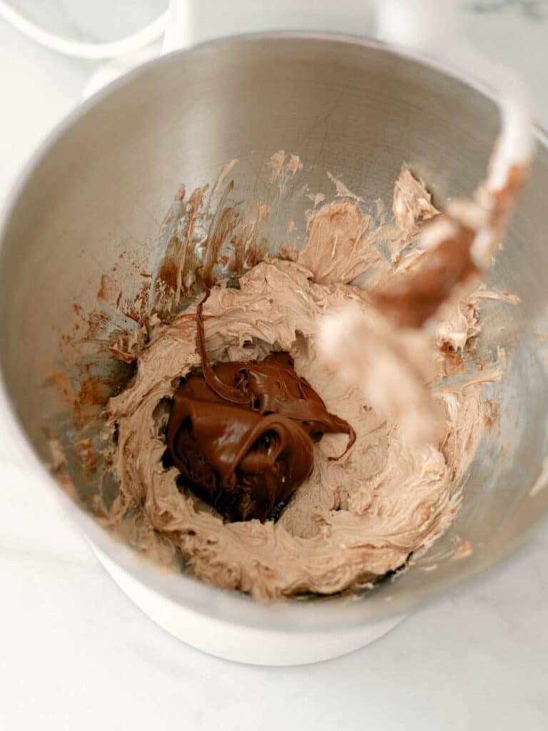 High angle shot of the whipped cream cheese and cocoa powder mixture with Nutella added to it, sitting in the center on the mixture.