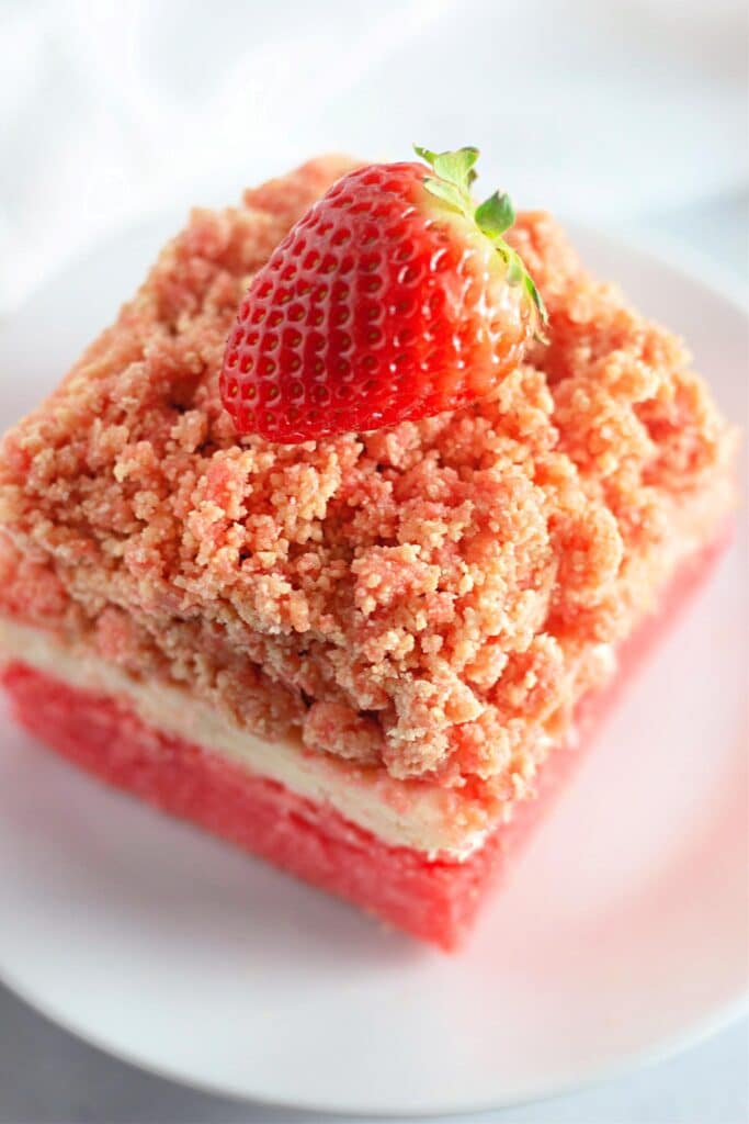 Strawberry Shortcake Crunch Bars with Box Cake Mix 17 High angle shot of one of the slices of Easy Strawberry Crunch Cake Bars on a white plate.