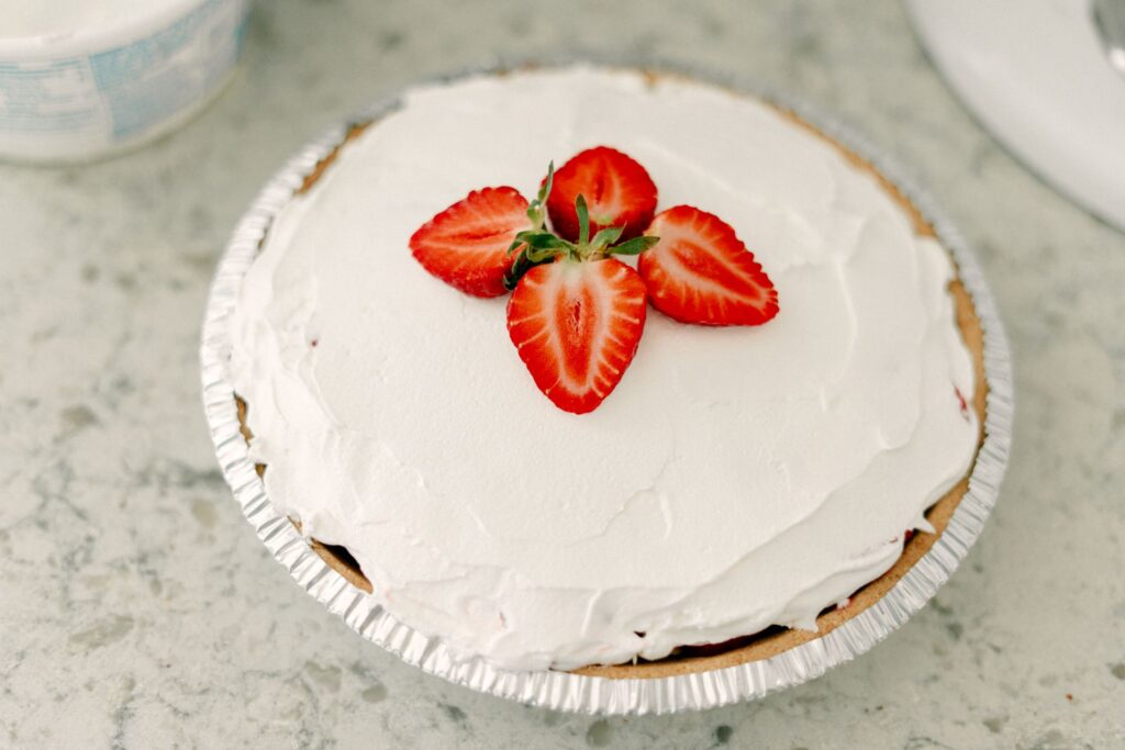 Best No-Bake Strawberry Cream Cheese Pie 16 High angle shot of The Best No-Bake Strawberry Cream Cheese Pie topped with fresh strawberries as garnish.