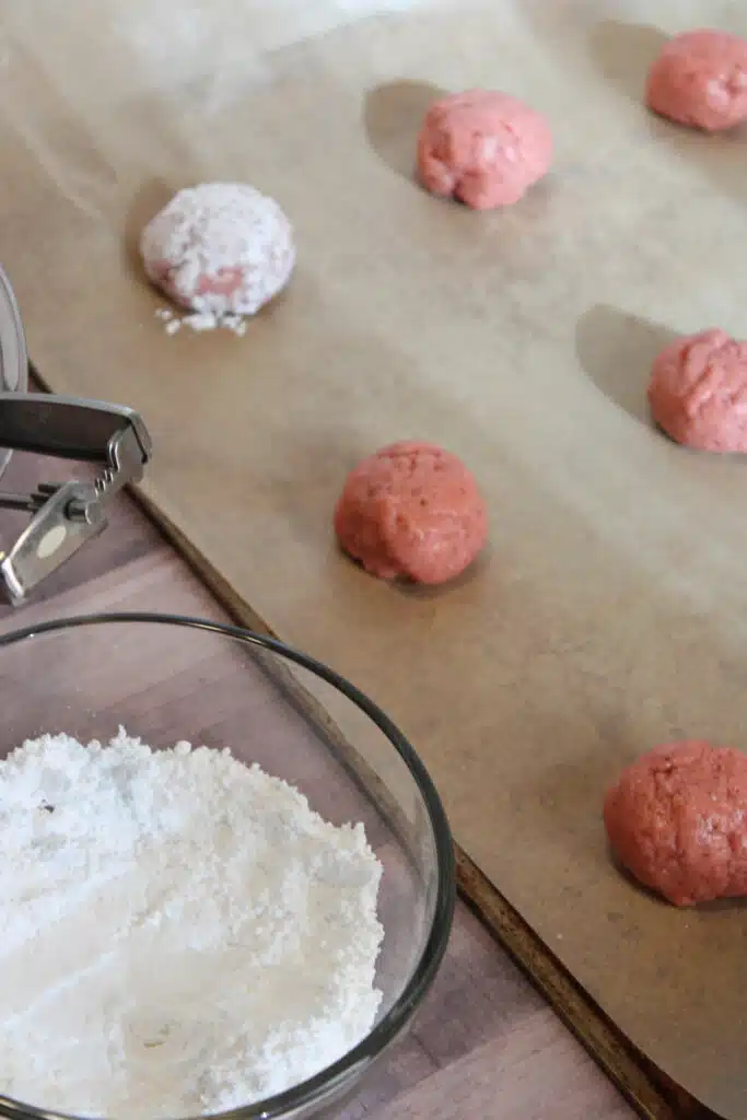 The Easiest Strawberry Cake Mix Crinkle Cookies (4 Ingredients + Vegan!) 12 strawberry cookie balls on parchment paper