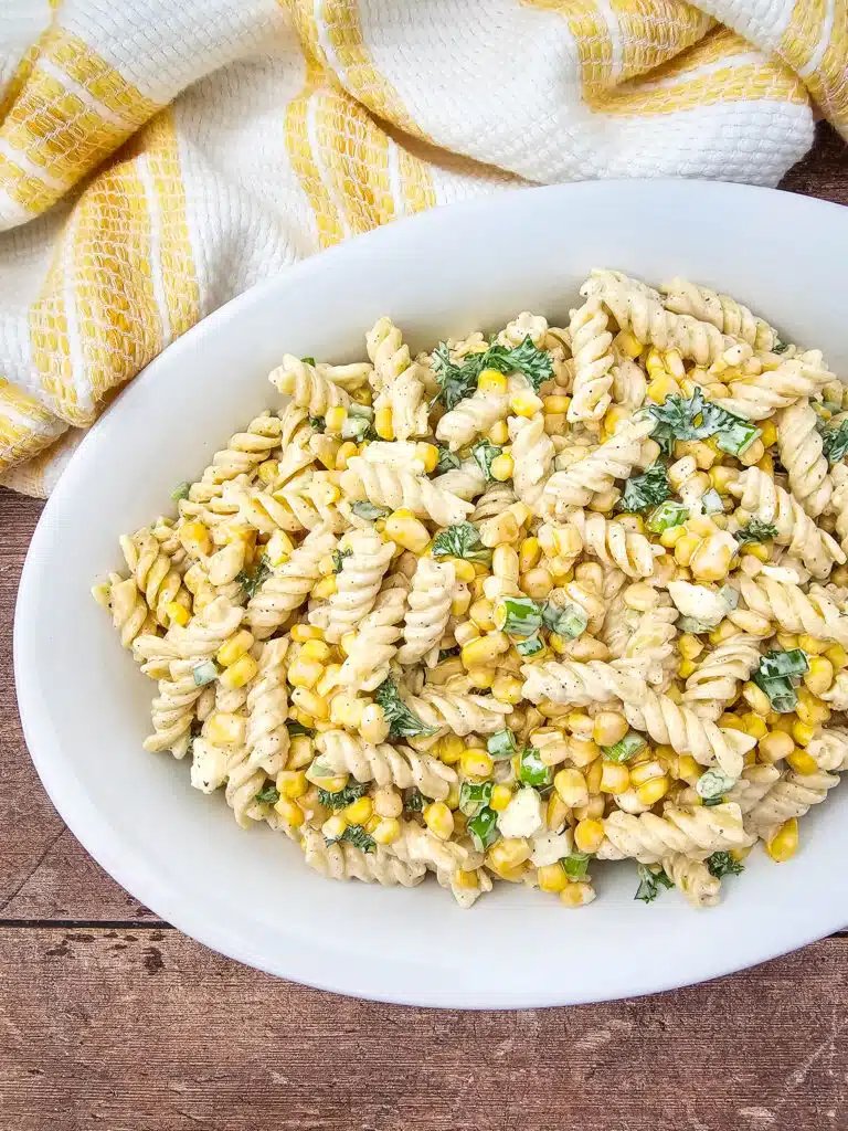 Overhead shot of a white oval platter with the finished Mouth-Watering Mexican Street Corn Pasta Salad in it.