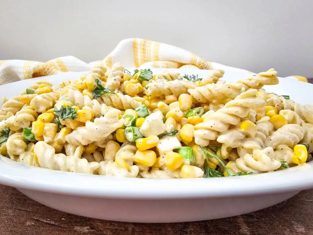 An oval platter with the Mouth-Watering Mexican Street Corn Pasta Salad.