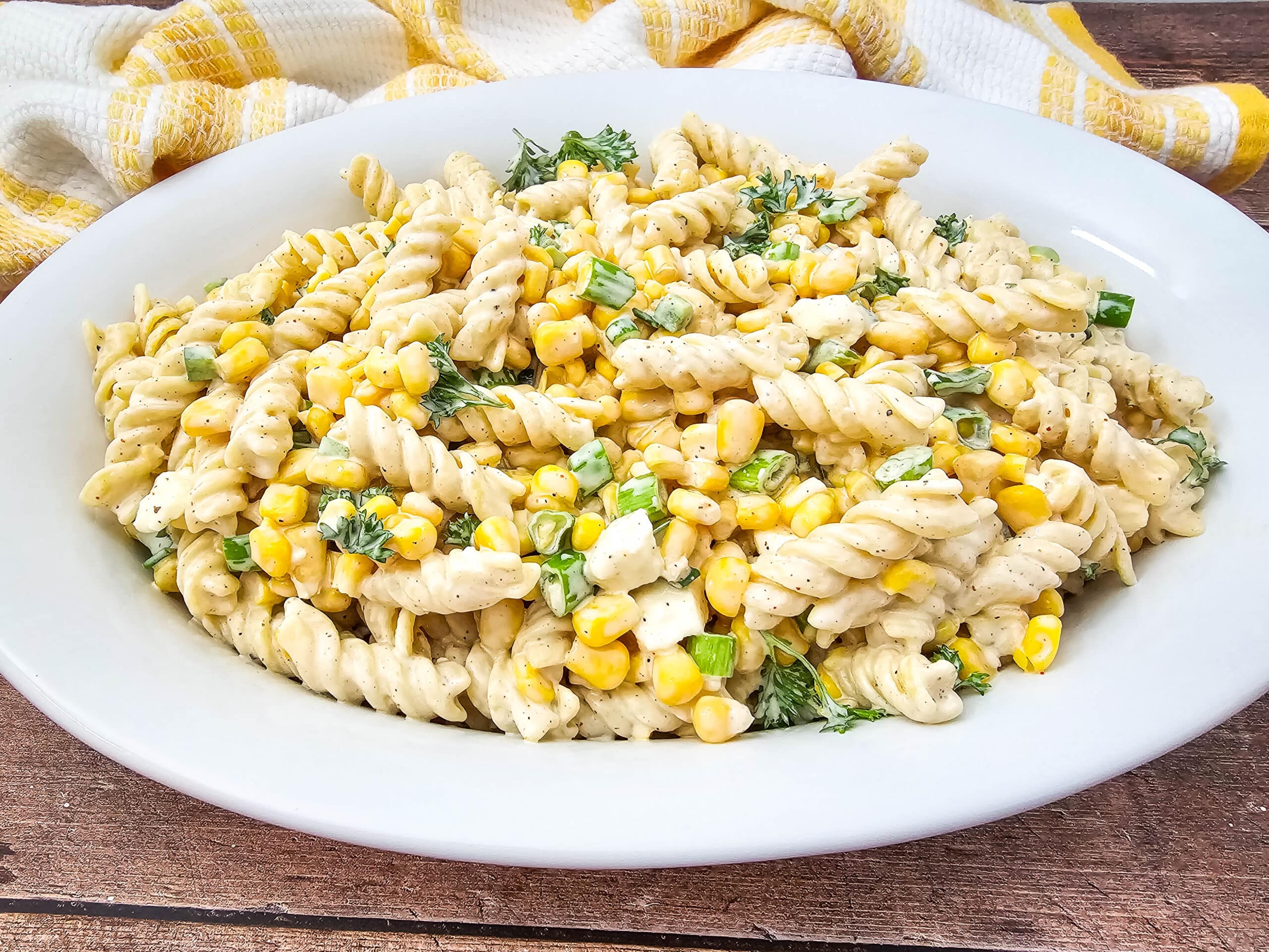 Closeup shot of Mouthwatering Mexican Street Corn Pasta Salad in an oval white platter.