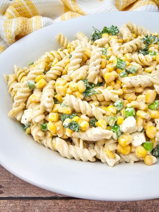 A partial shot of the finished Mexican Street Corn Pasta Salad on a white platter.