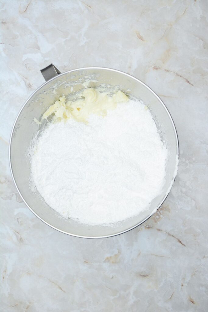Flat lay shot of a mixing bowl with whipped cream and powdered sugar in it.