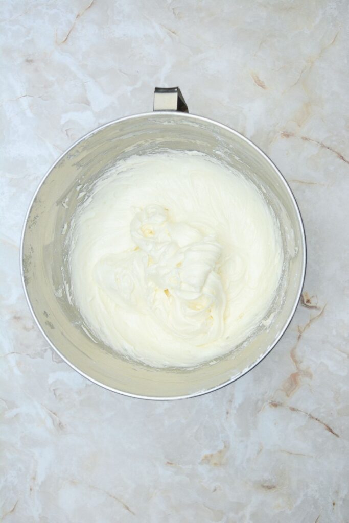 Flat lay shot of a mixing bowl with the cream cheese frosting in it.