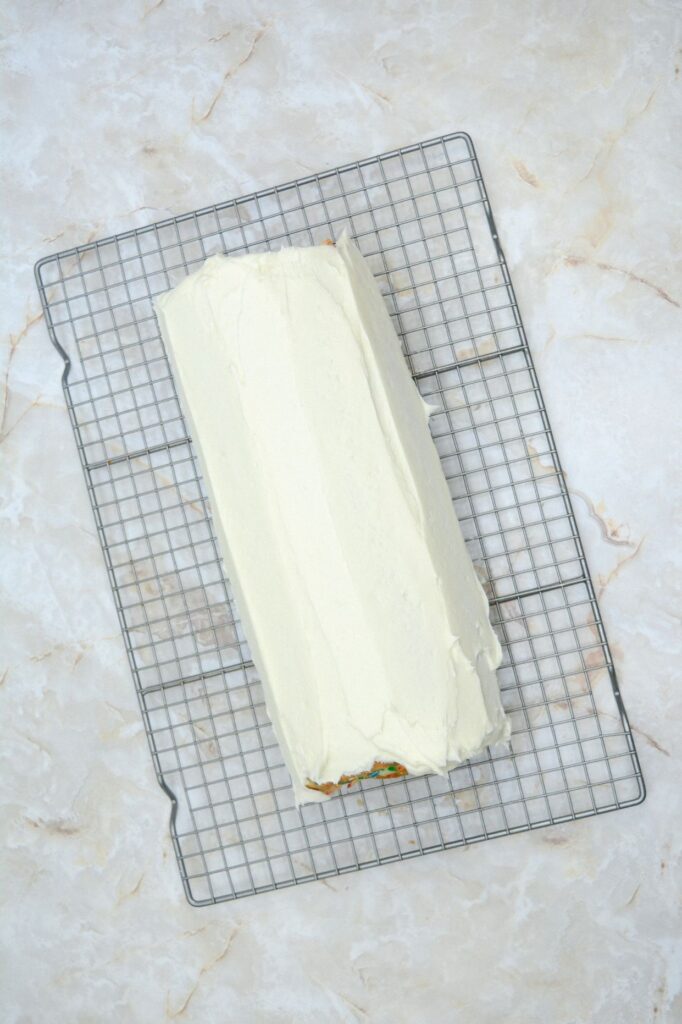 Flat lay shot of the frosted roll cake on a wire rack.