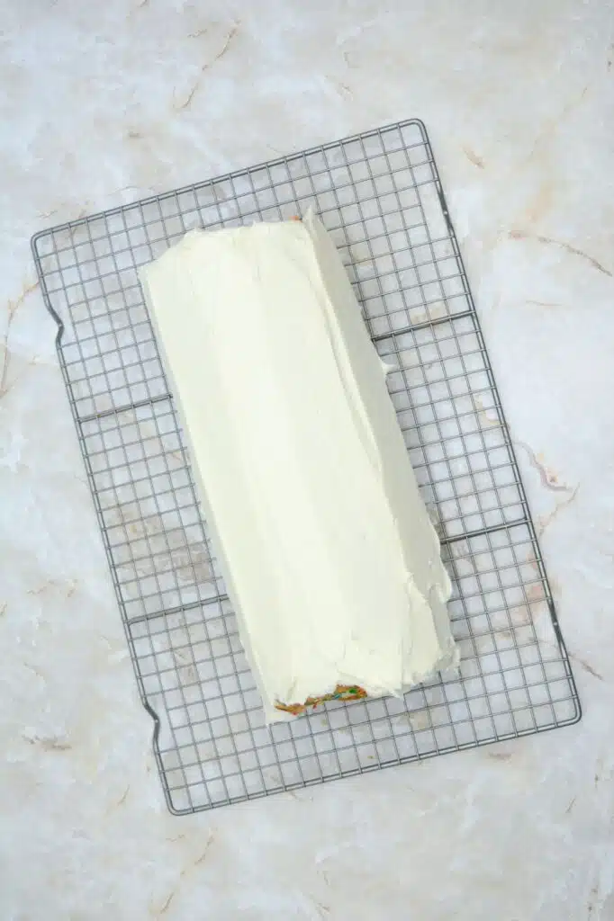 Easy From Scratch Confetti Birthday Cake Roll Recipe with Cream Cheese Frosting 28 Flat lay shot of the frosted roll cake on a wire rack.
