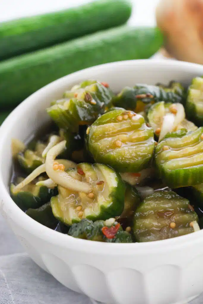 Closeup shot of a Bread and Butter Pickles in a white bowl.