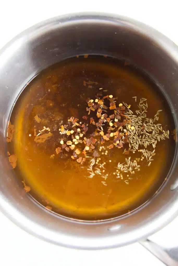 A small saucepan with vinegar and spices in it.