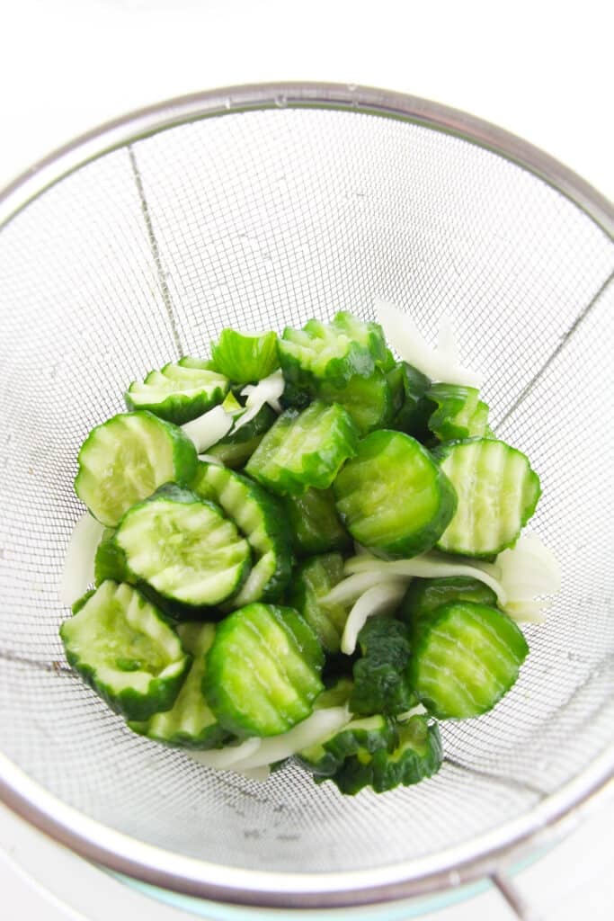 Easy Refrigerator Bread and Butter Pickles 12 Salted cucumbers and onions rinsed in a strainer.