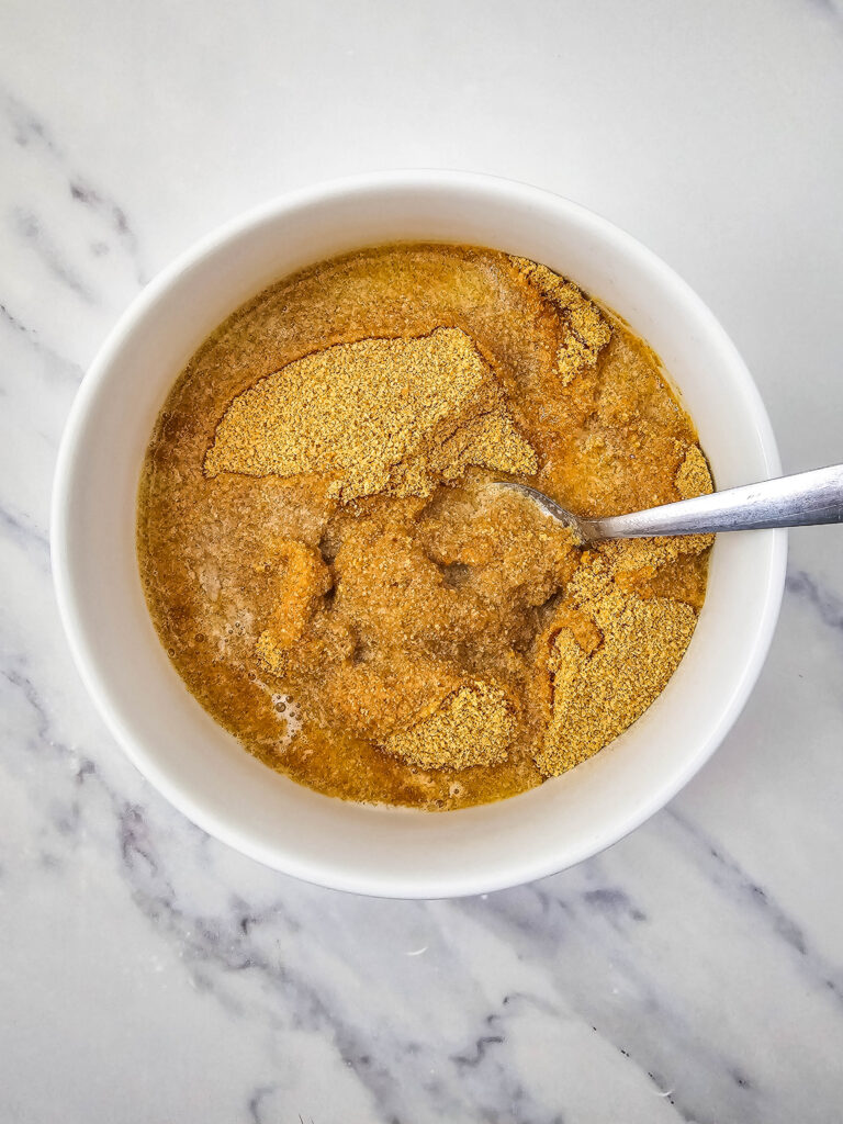 No Bake Pineapple Dream Dessert 6 A bowl of brown liquid with a spoon.