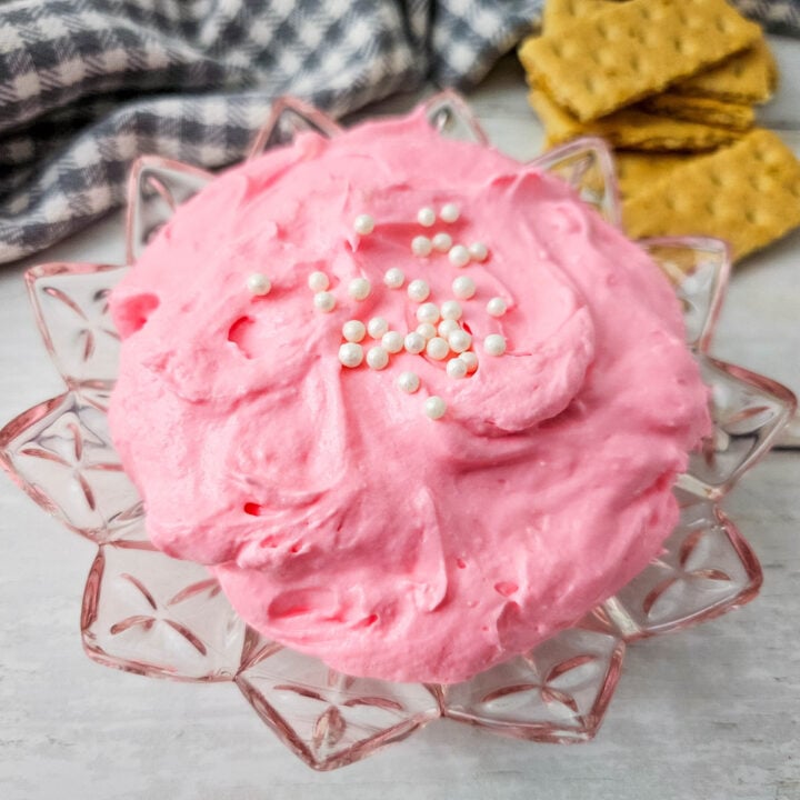 A glass flower like bowl with Pink Marshmallow Fluff Dip in it.
